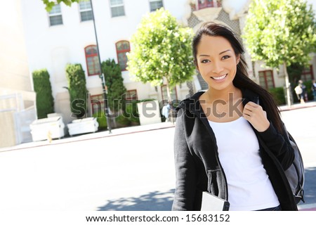 A cute young asian woman walking to class on college campus