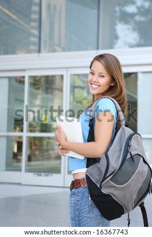 Attractive young woman at school library holding book