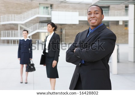 A handsome african american business man with team at office building