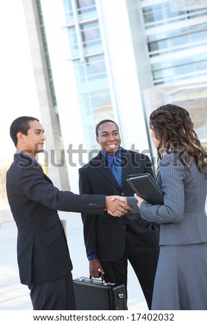 A diverse ethnic business team shaking hands at office building