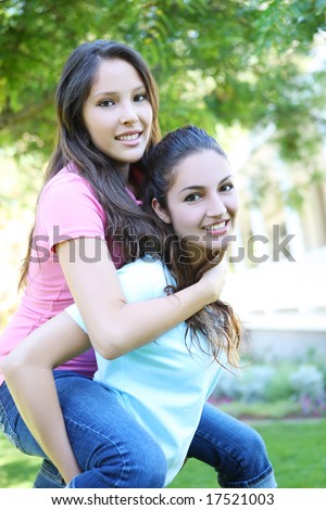 Two attractive hispanic sisters displaying the love of family at home