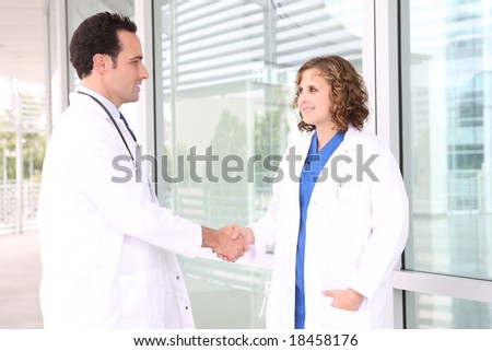 A man and woman medical team at hospital shaking hands