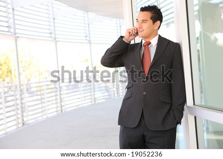 A handsome business man on the phone at office building