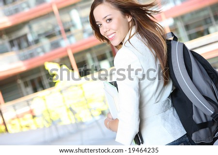 A pretty, young woman on the university campus walking to class