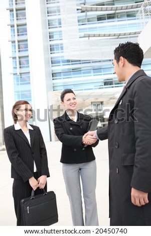 Attractive man and woman business team shaking hands at company