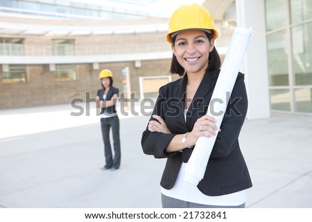 Two pretty women working as architects on a construction site