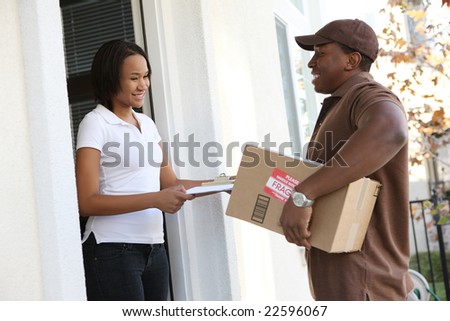 A handsome young delivery man delivering a package to house