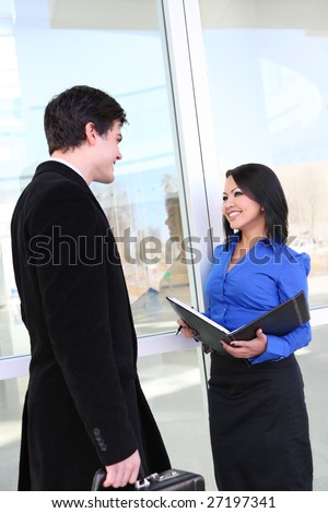 An attractive young diverse business man and woman team in office environment
