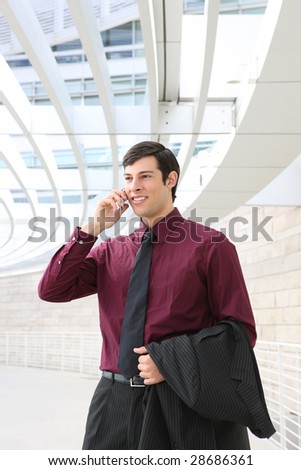 A young, handsome business man on phone at place of work