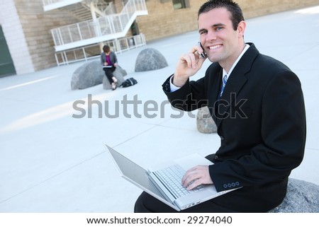 A young, handsome business man on laptop computer at office building