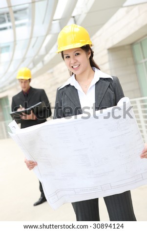 Attractive man and woman architects on building construction site