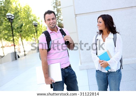 Attractive man and woman students walking to class at college