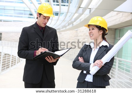 Attractive man and woman architects on building construction site
