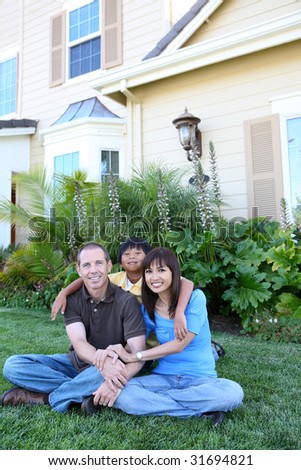 Attractive happy family outside their home having fun