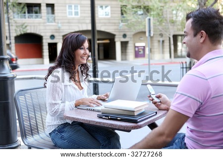 A man and woman student at school studying outside library