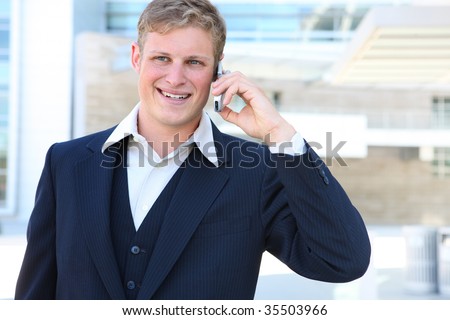 A handsome young business man on phone outside office building