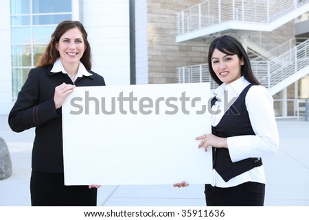 A young pretty business woman team holding a sign