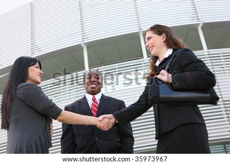 Attractive business man and women team at office building shaking hands