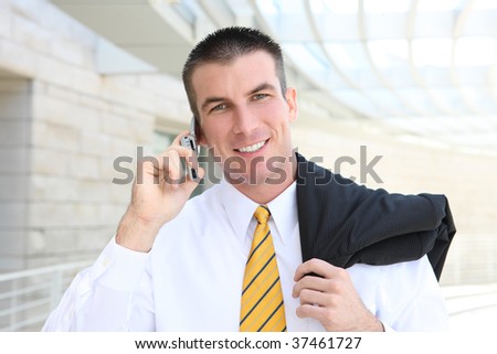 A young, handsome business man at the office building on phone