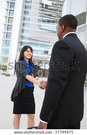 Attractive business man and women team at office building shaking hands