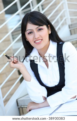 A pretty Indian business woman at company with notebook and pen