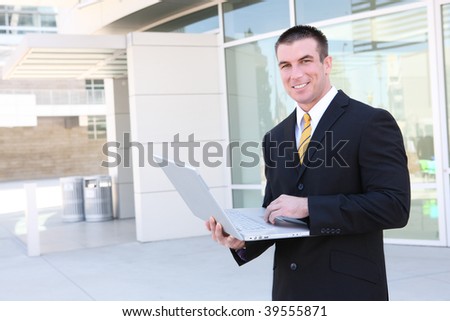 A handsome business man using laptop computer at office building