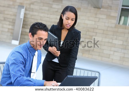 A diverse man and woman business team at their company office building on laptop computer