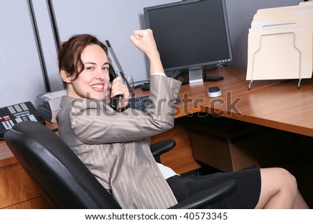 A pretty business woman inside office celebrating success