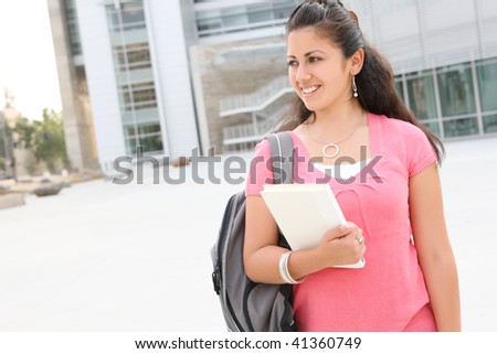 A cute young woman walking to class  on  college campus