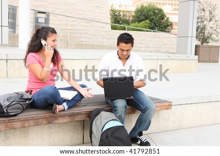 Man and woman friends at college campus studying with laptop computer
