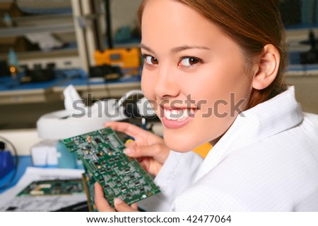 Pretty women technician working on computer parts in the lab