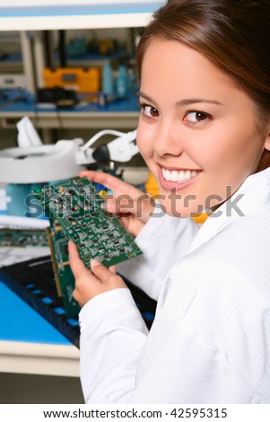 Pretty women technician working on computer parts in the lab