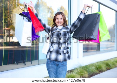 A pretty woman shopping with colorful bags walking to the next store