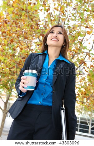 A pretty asian business woman walking with coffee