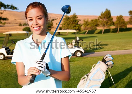 A young, cute woman golfer ready to hit on the fairway