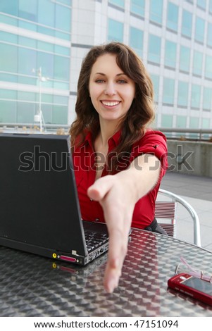 Pretty young business woman on laptop computer at office building