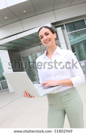 A pretty business woman at office building on laptop computer