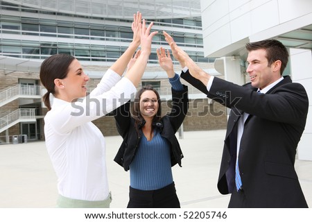 A happy attractive man and woman business team celebrating at office building