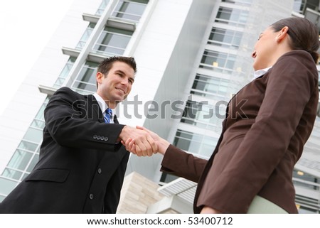 A attractive man and woman business team handshake at office building