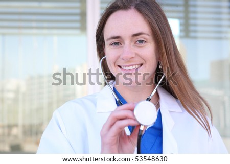 Smiling medical doctor woman with stethoscope outside hospital office