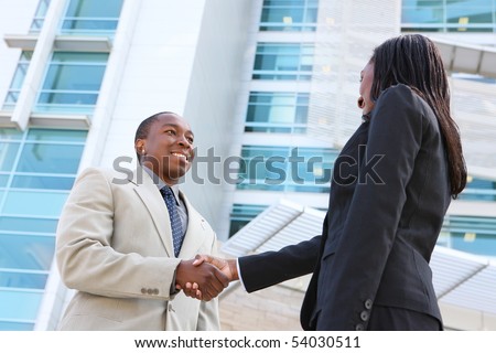An african american business man and woman team handshake at office building