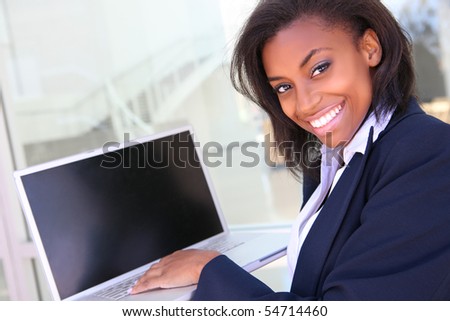 A pretty young african american business woman on laptop computer