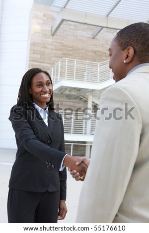 An african american business man and woman team handshake at office building