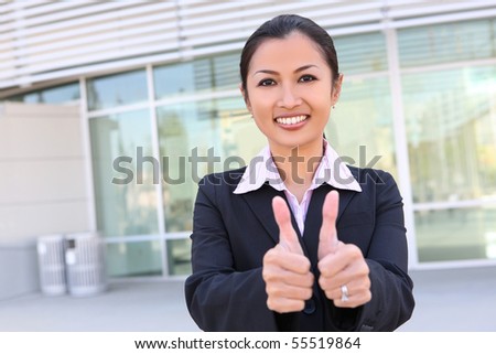 A pretty asian business woman with thumbs up celebrating success