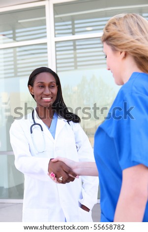 Attractive, diverse medical woman team at hospital handshake