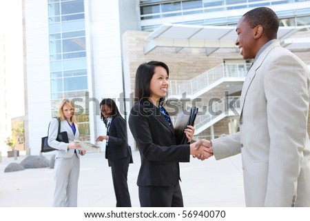 A diverse business man and woman team handshake at office building