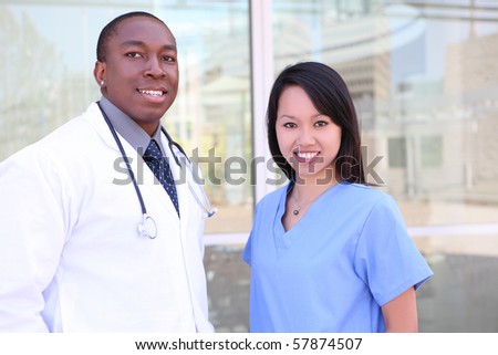An ethnic happy medical man and woman team outside hospital