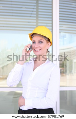 A pretty blonde woman working as architect on a construction site