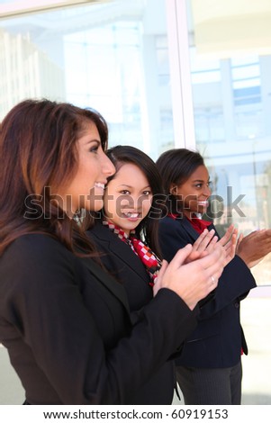A diverse attractive woman business team at office building clapping