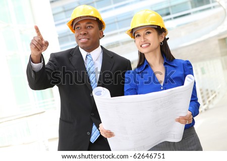 A diverse  woman and man working as architects on a construction site (Focus on Woman)